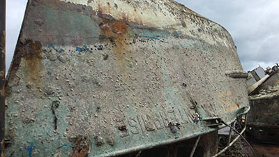 A deteriorating boat hull on land
