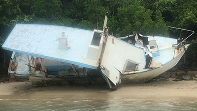 A damaged boat on shore