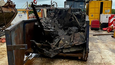 A boat in a skip bin for disposal