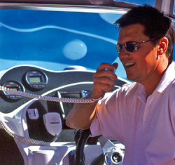 An image of a man speaking on a marine radio in a boat